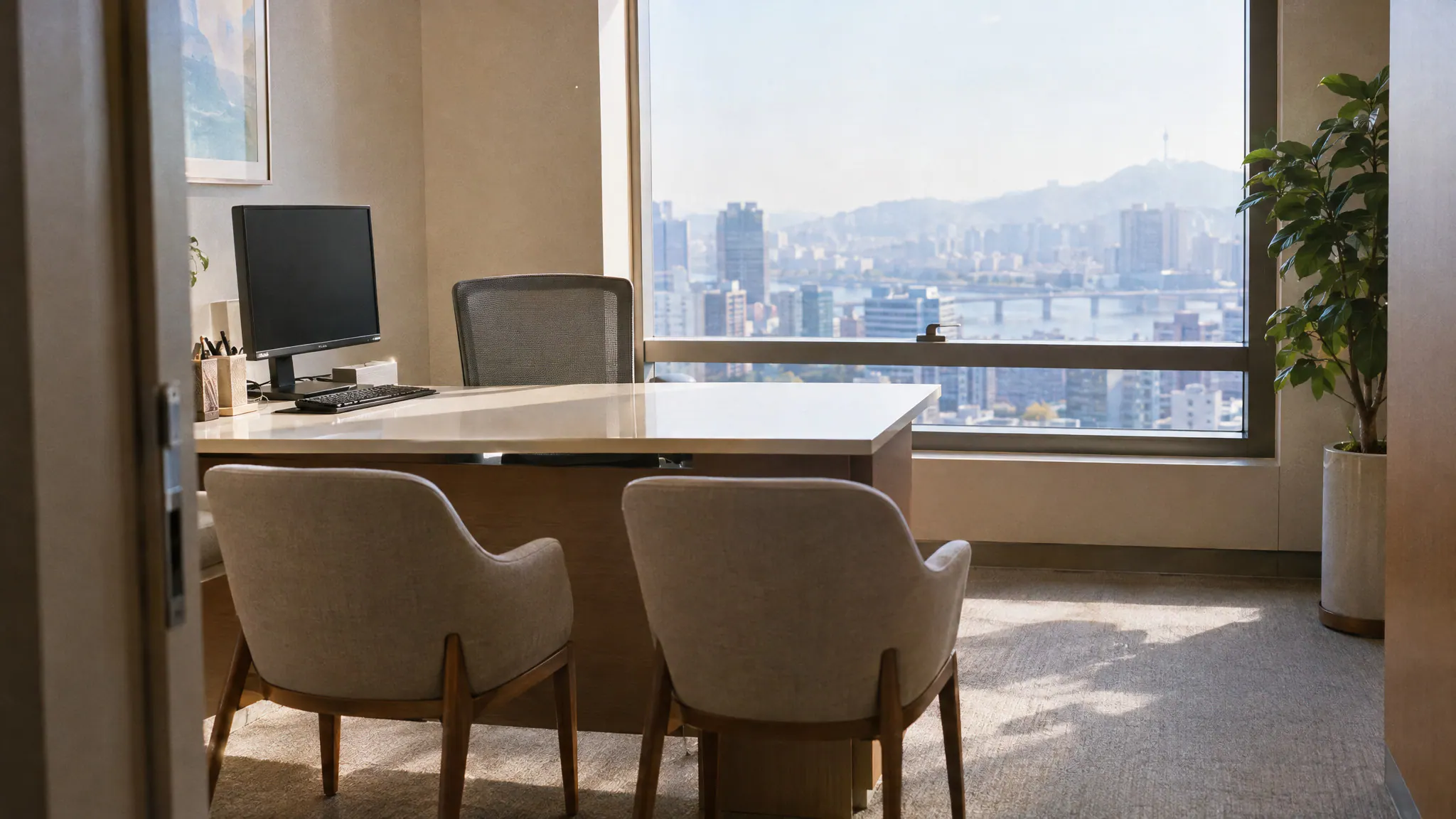 An empty consultation room at a private hospital in Seoul with a desk, two chairs and a city view